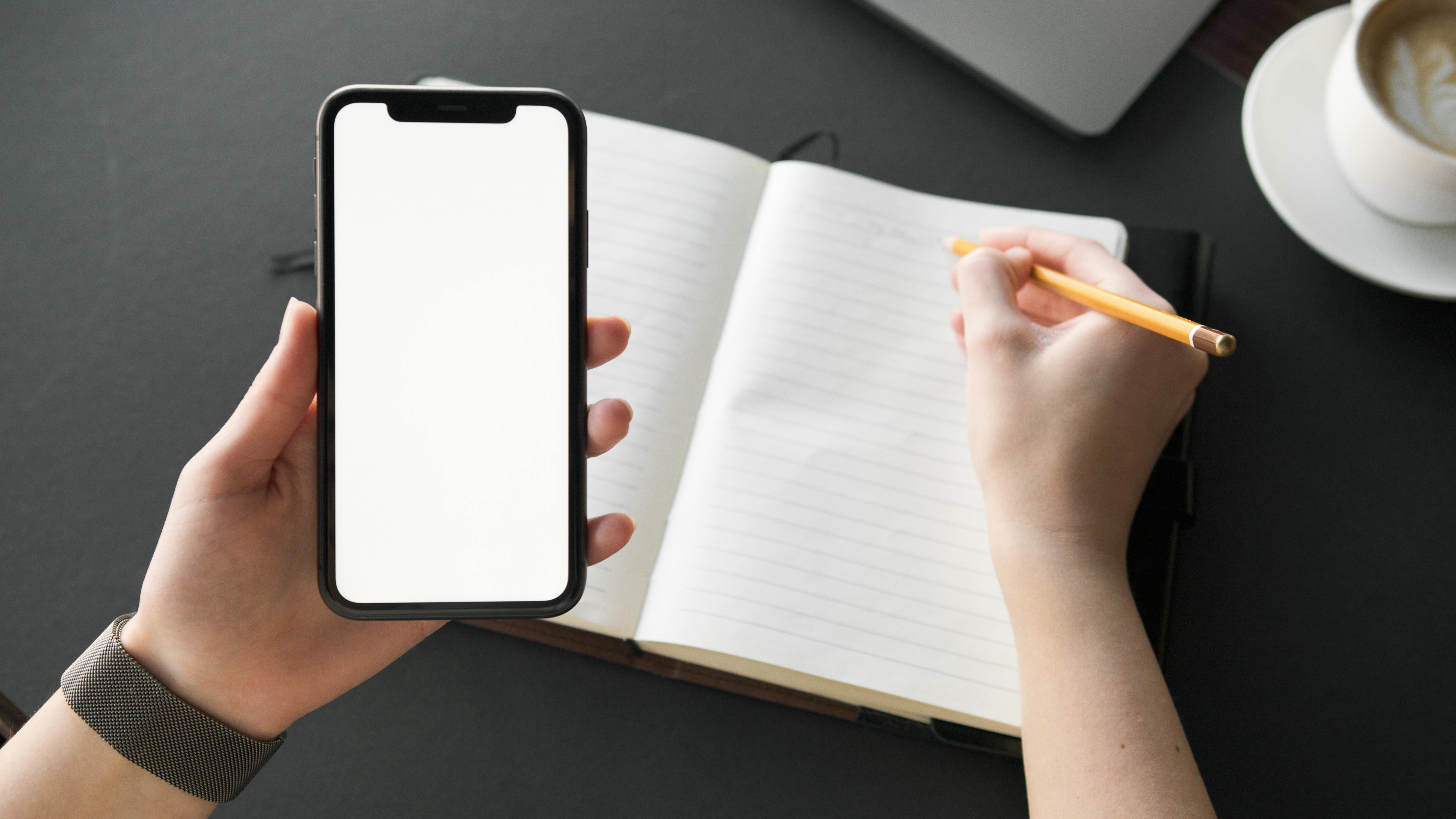 Notes scribbled in a notebook and identical jottings displayed on a smartphone screen