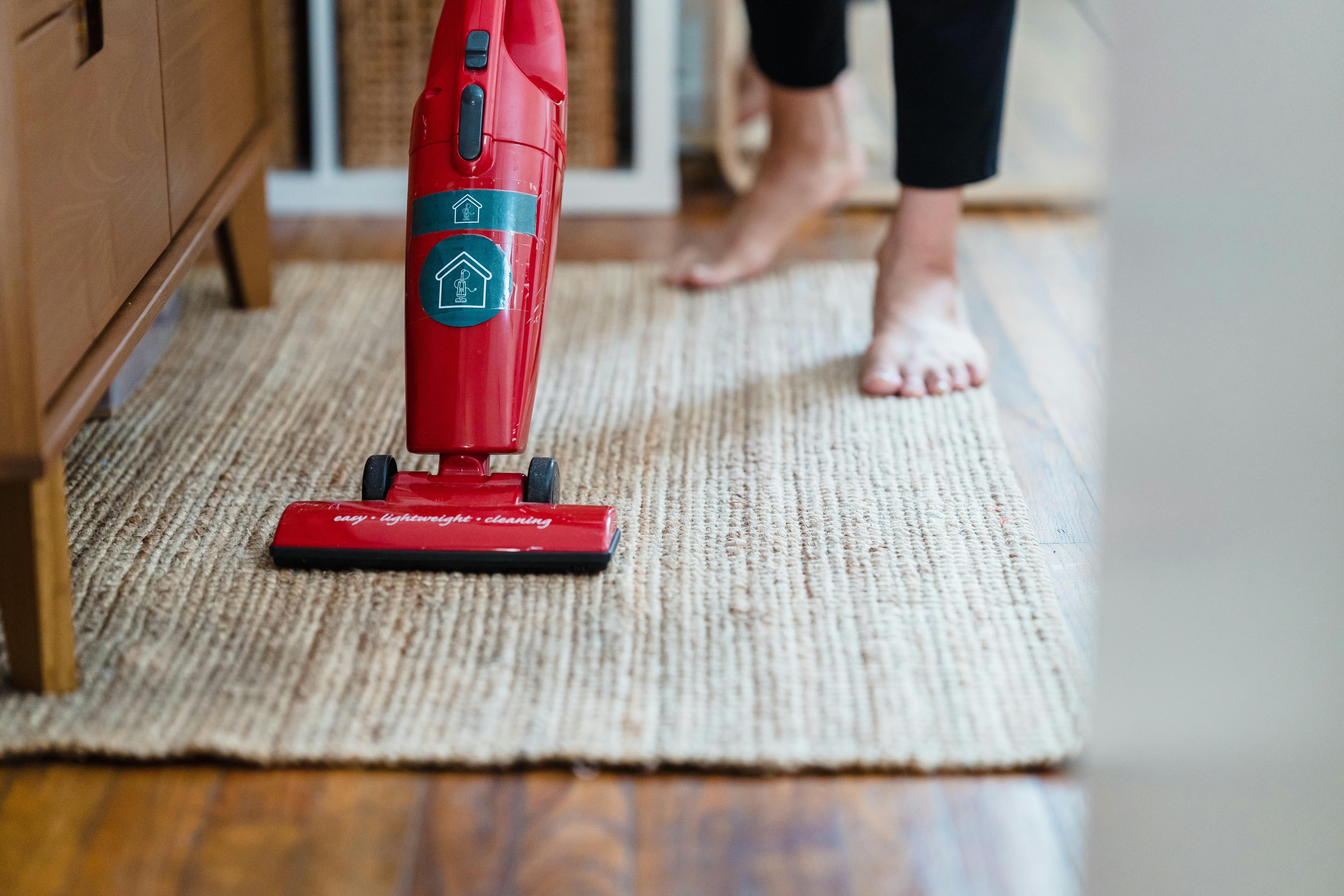 Rug vacuum efficiently gathering crumbs on its surface Rug vacuum efficiently capturing loose particles on thick carpet surface