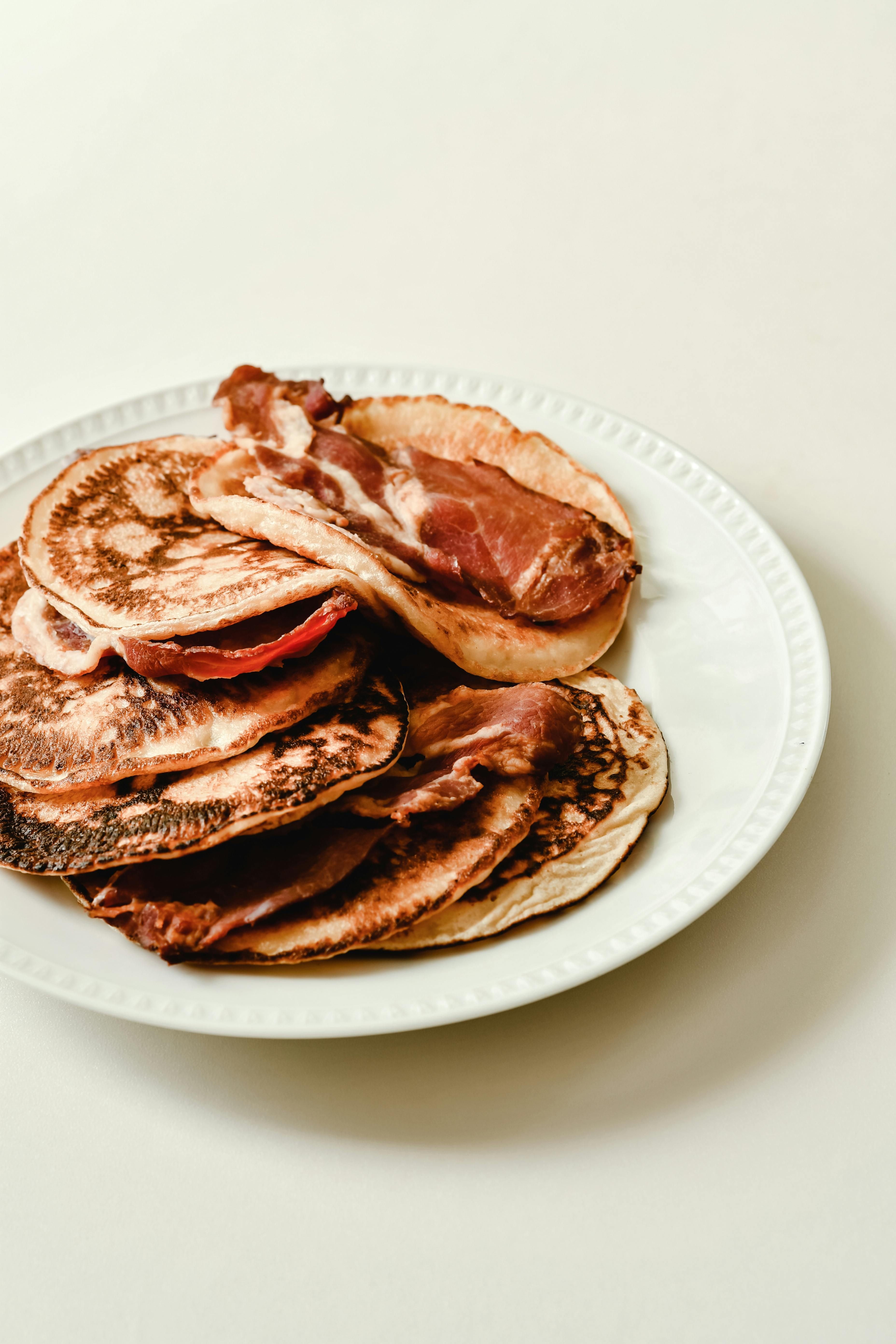 Sizzling breakfast affair on an electric griddle, featuring eggs, bacon, and pancakes.