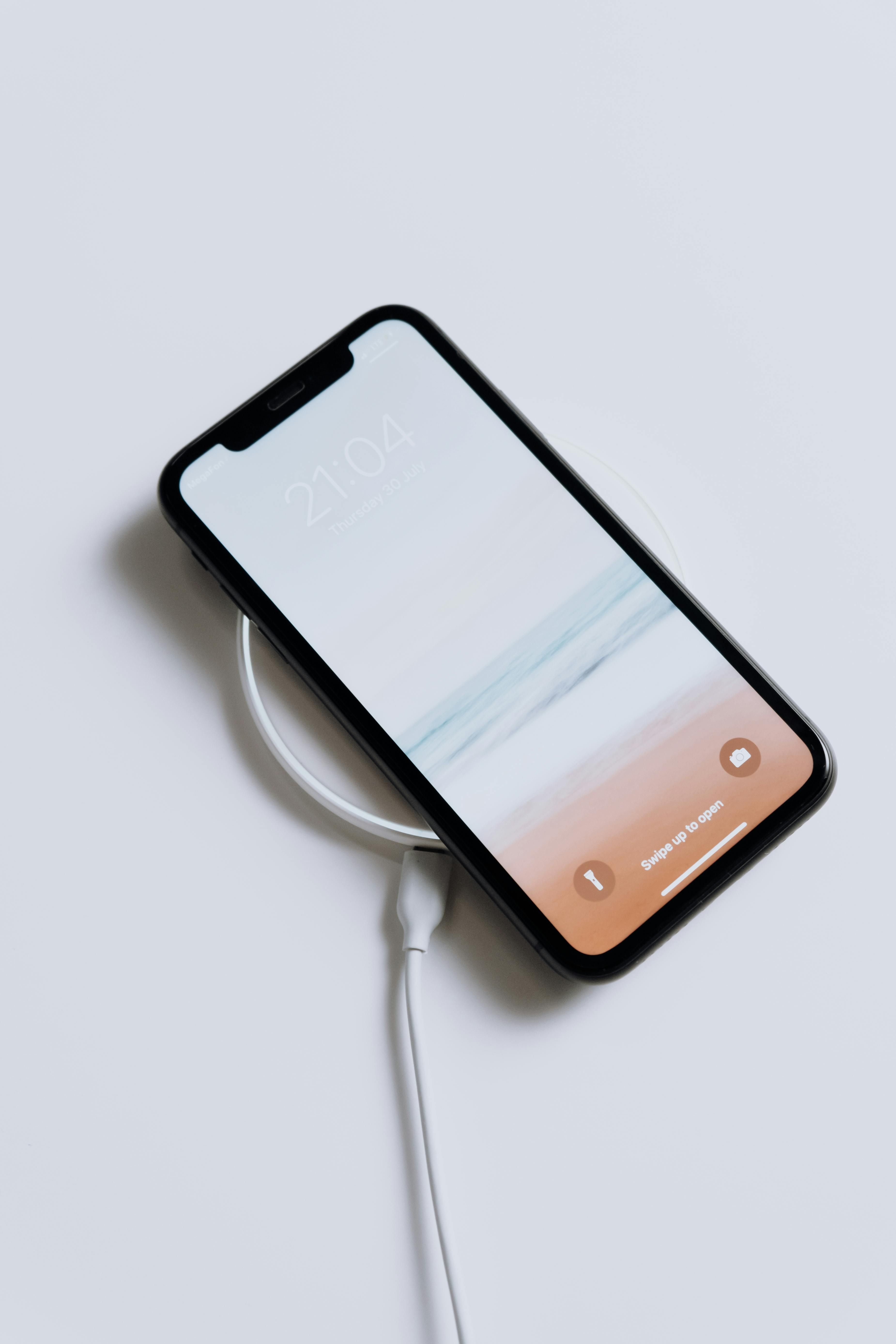 Wireless charger powers up a handheld device. Wireless charging device powers up the mobile phone.
