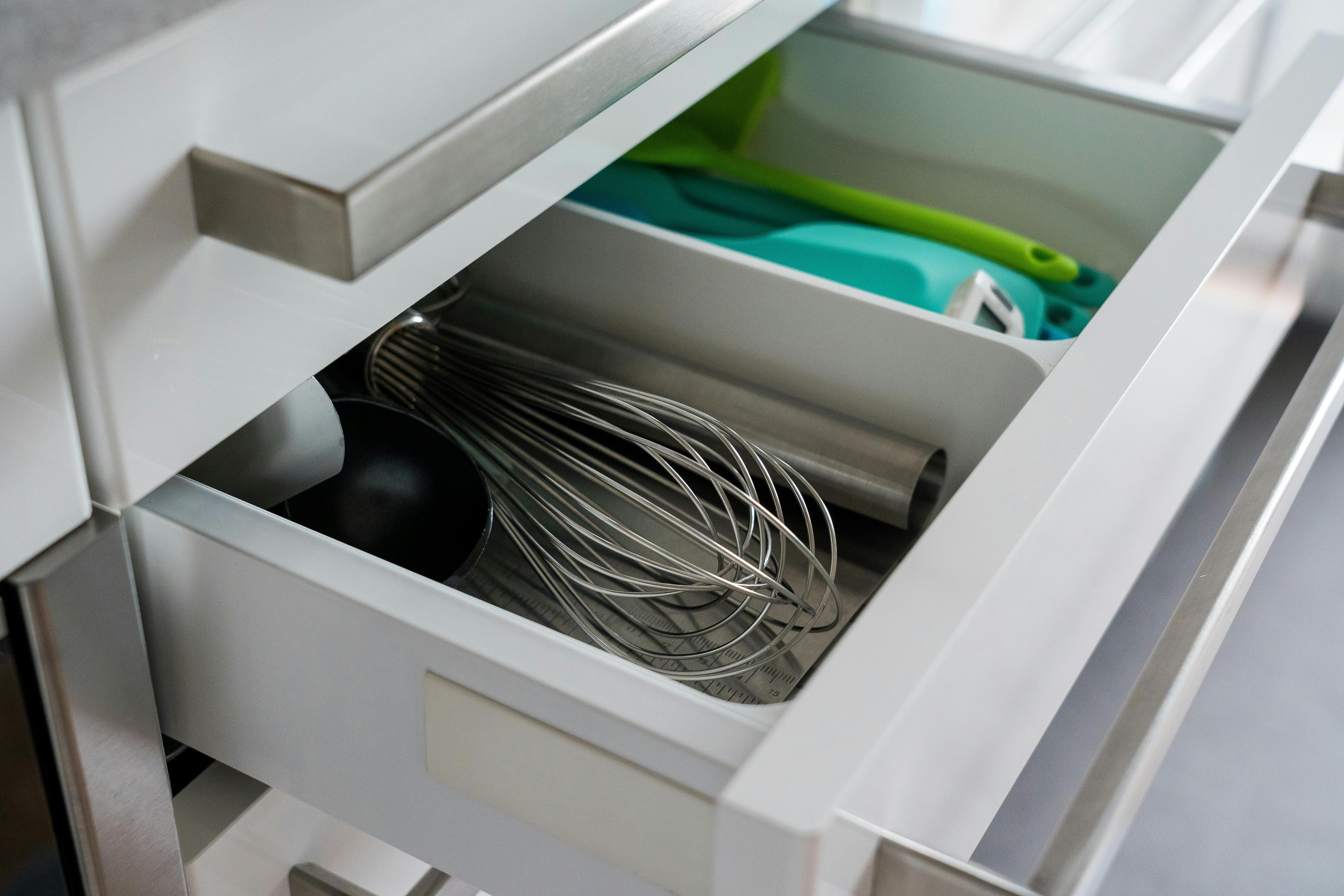 A drawer housing various utensils also contains an event organizer. Found organizer packed with kitchen tools inside it