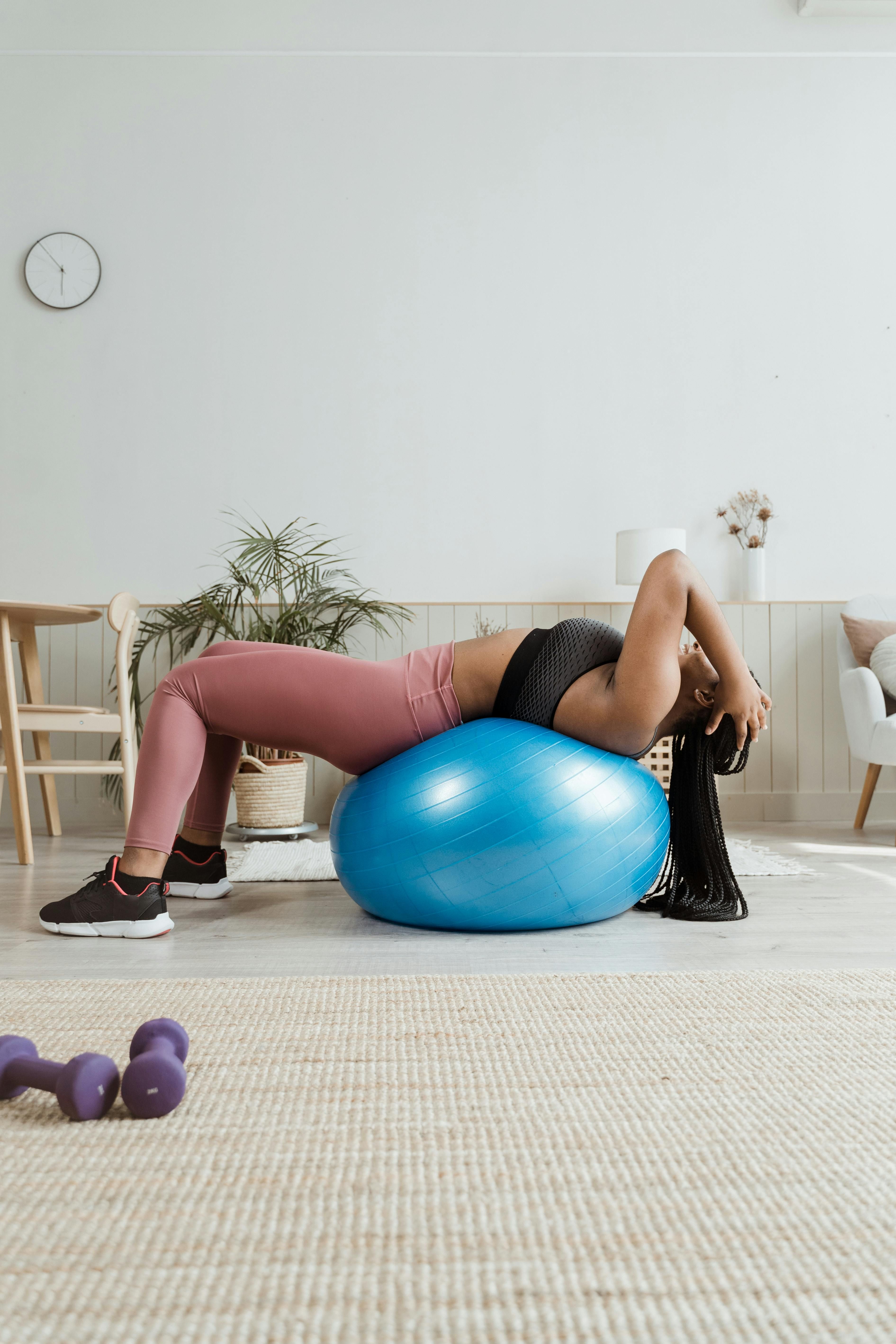 User exercises on carpet using black ab roller wheel for core workout. User practices ab workouts on a carpet utilizing a black roller wheel