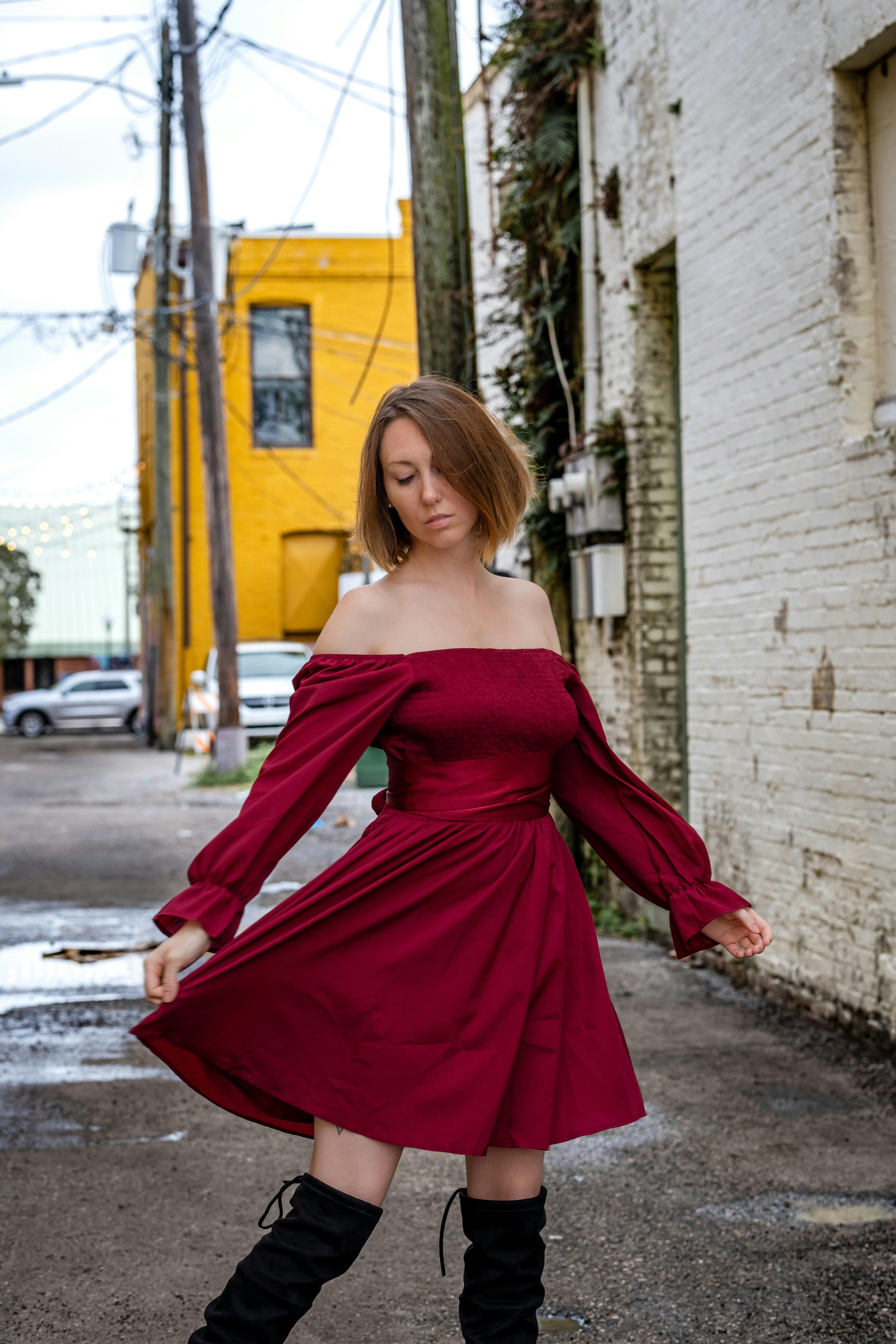 A woman sporting a burgundy, three-quarter-sleeve button-down gown. A fashion model sporting a burgundy button-down dress with three-quarter length sleeves.