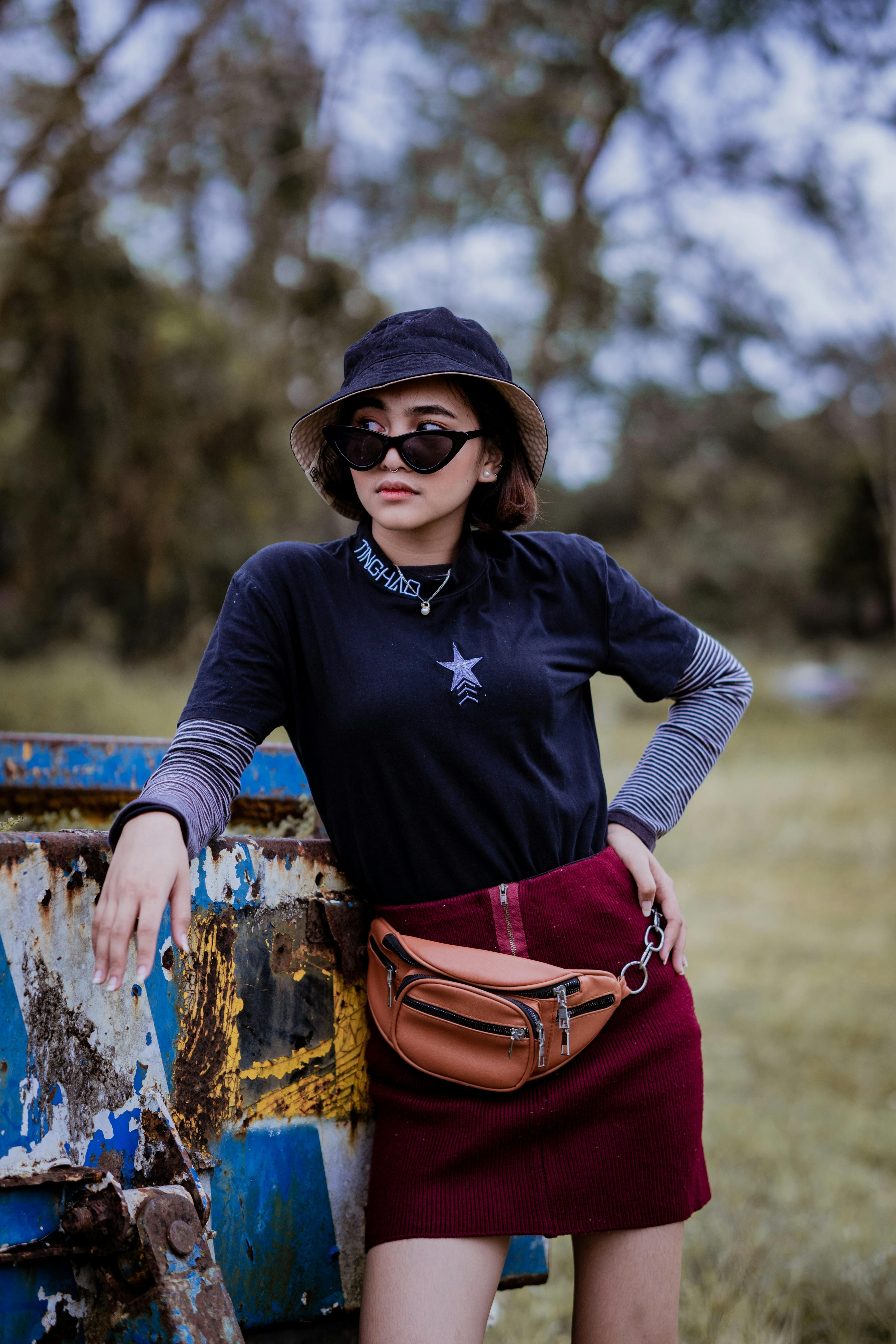 Woman donning red sweater dress, black crossbody bag, and hat featured in style article. Red-clad model sporting sweater dress, black crossbody bag, and a hat.