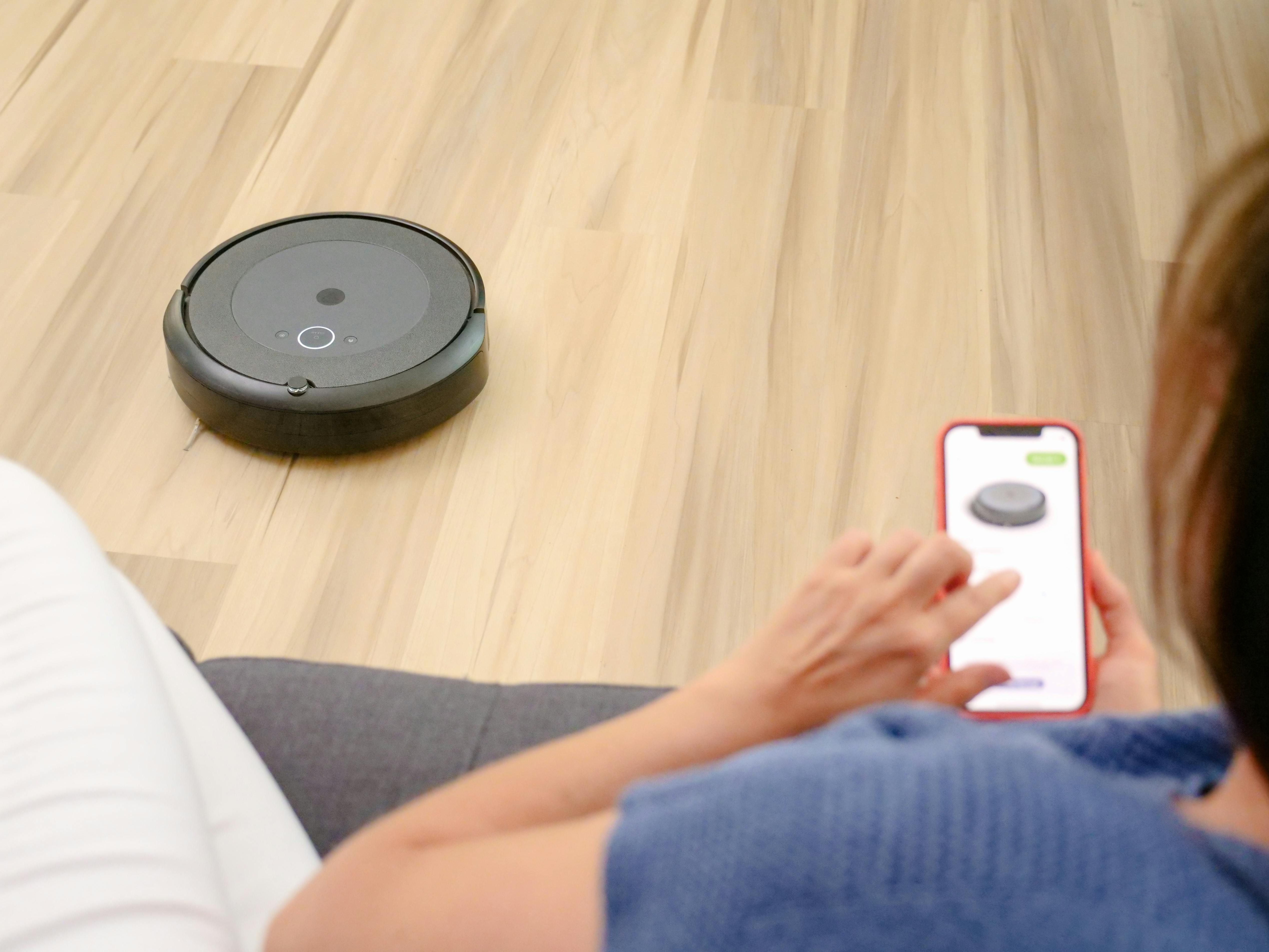 Vacuum Cleaner iRobot Roomba Suctioning a Polished Wood Surface
