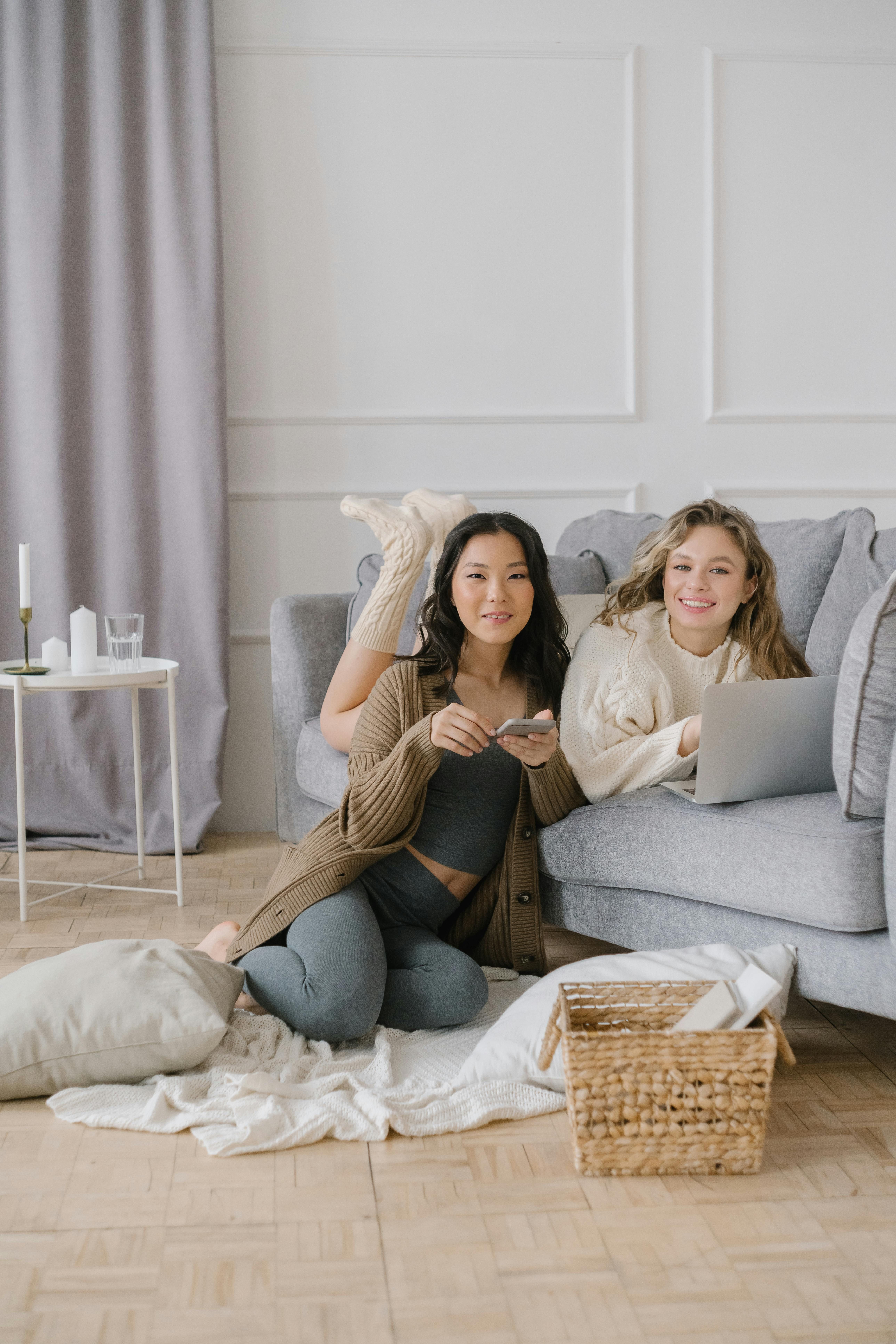 Living space adorned with a contemporary green sofa and accompanying ottoman, showcasing a mobile device being charged on the armrest. Living space showcasing a contemporary green sofa and coordinating ottoman, with a mobile device resting on the armrest, in a cozy home environment.