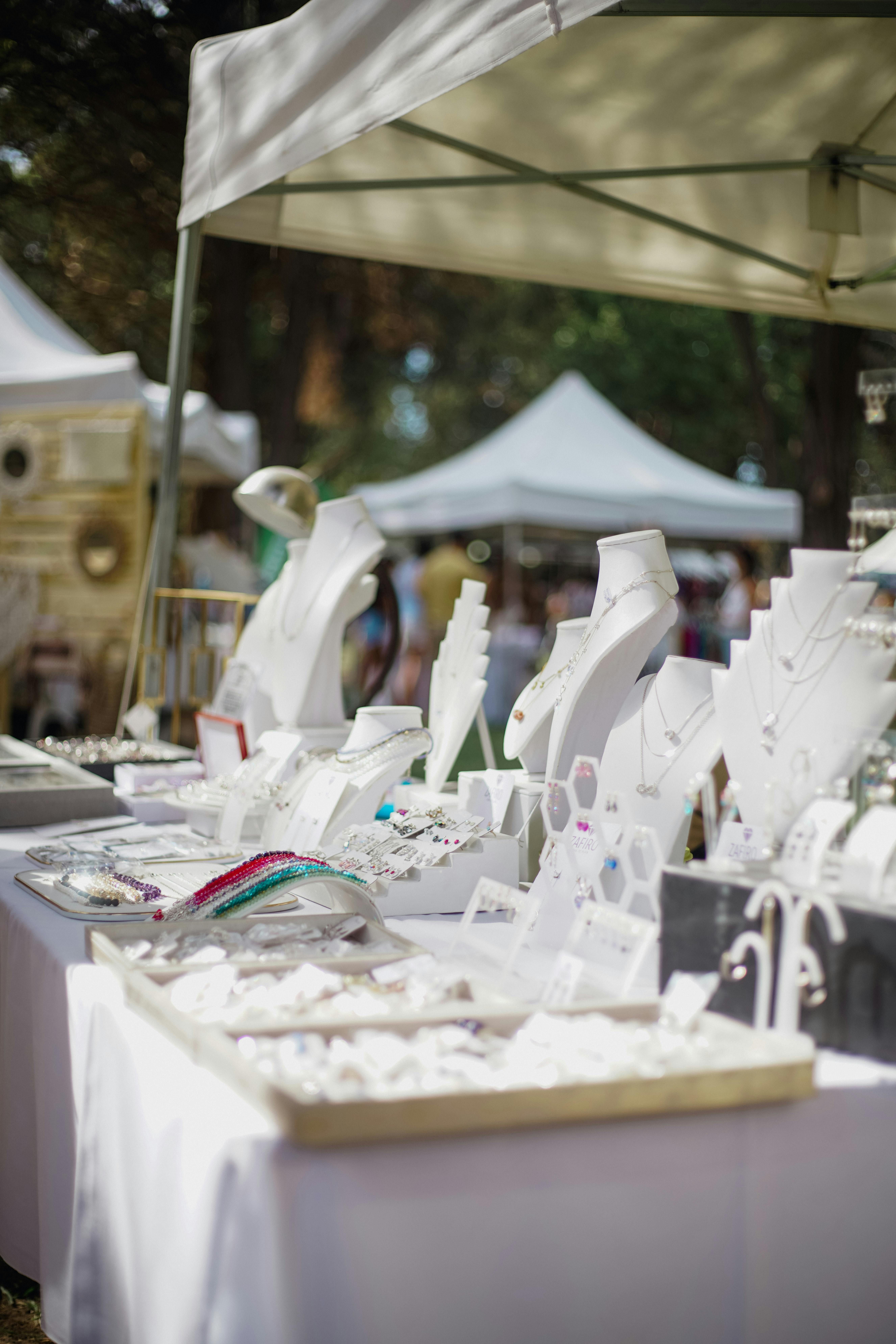 Jewelry display showcasing necklaces and rings, arranged on a three-tier, silver T-shaped stand. Three-tier silver T-shaped ornament displaying various necklaces and rings from different angles