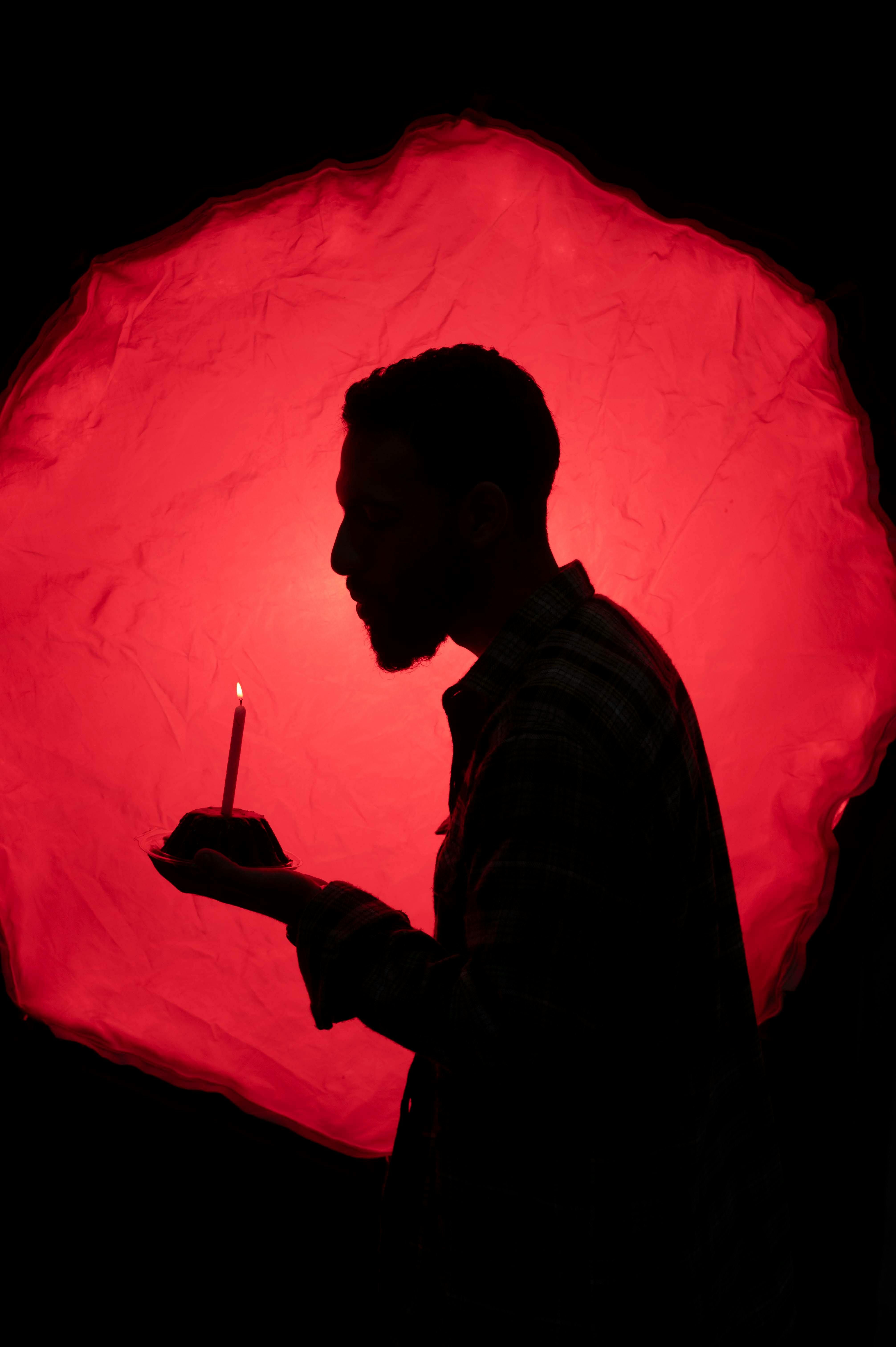 burning crimson waxed candle A crimson candle illuminated the dark room.
