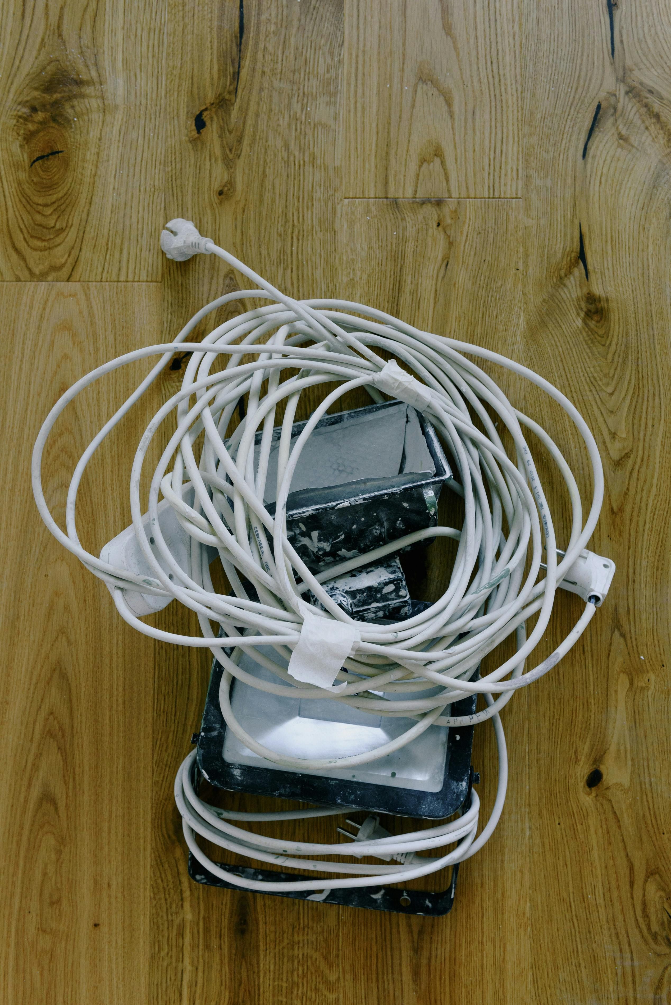 Examiner demonstrates a transformation of a cord emerging from behind a wardrobe, followed by its concealment using a flush-mounted outlet plug