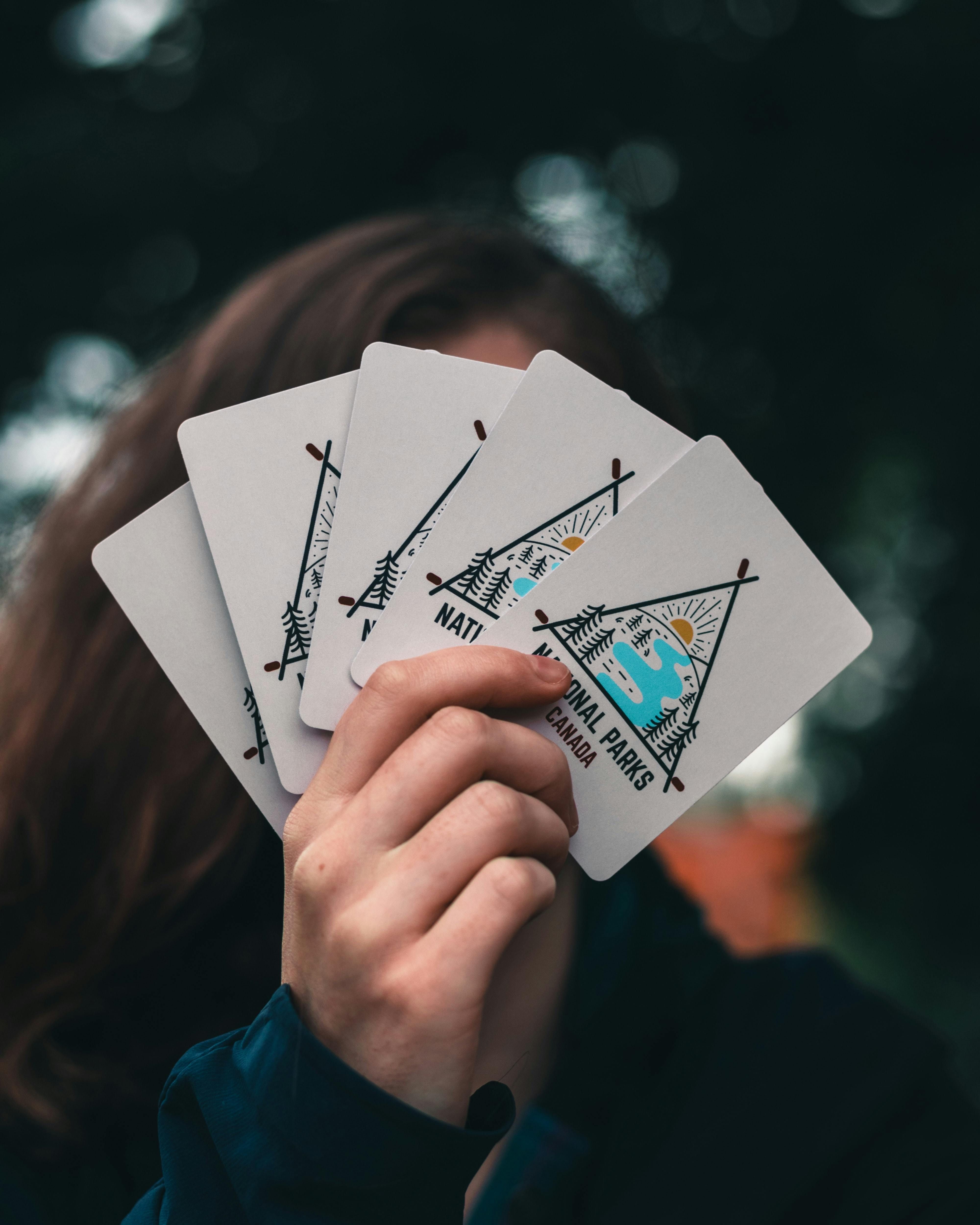 Photograph displays a person showing off spread-out Joyoldelf playing cards.