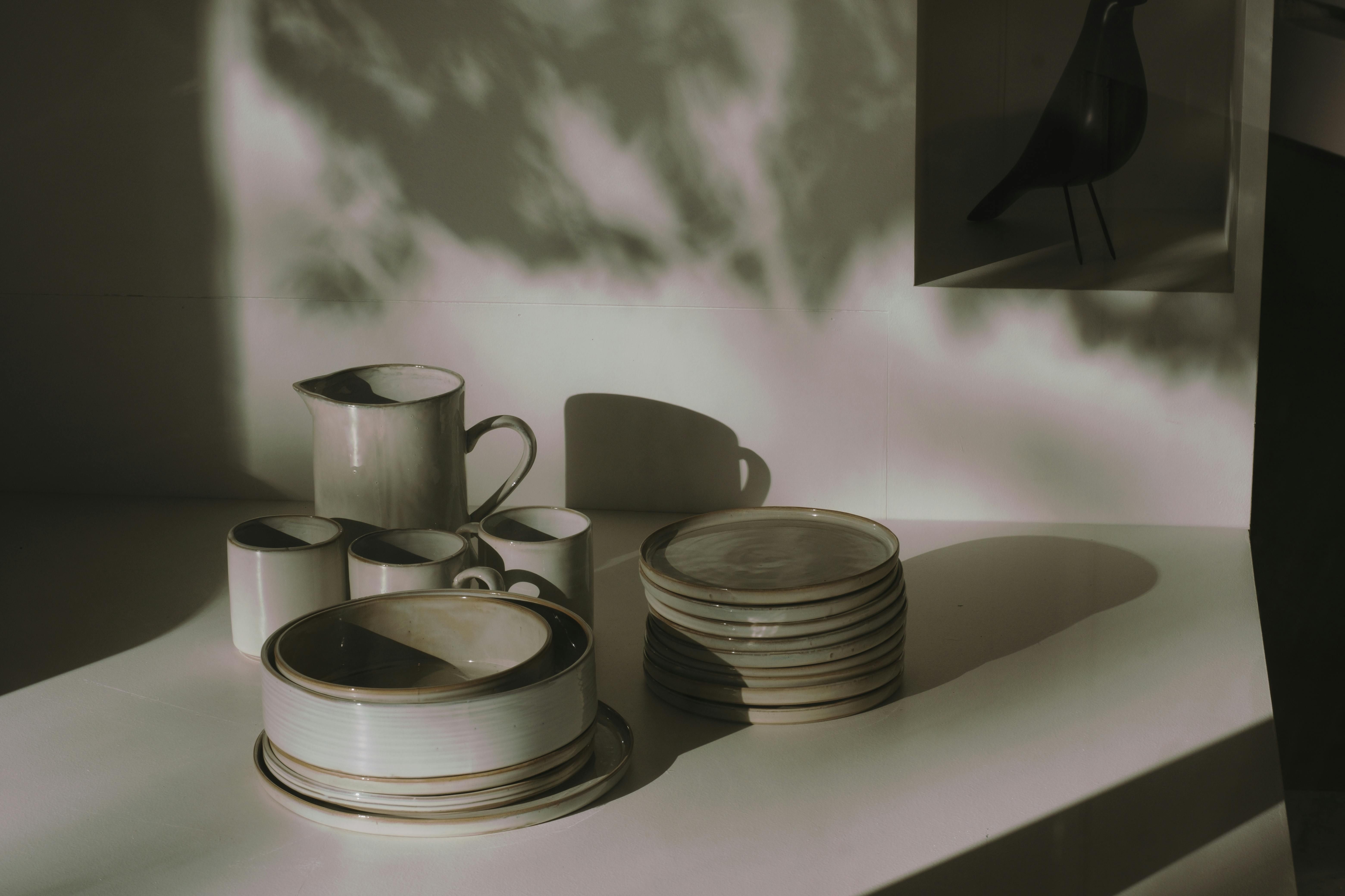 Tableware arrangement: bowls, plates, cups, and cutlery placed on a surface assortment of bowls, dishes, glasses, and cutlery arranged on a tabletop