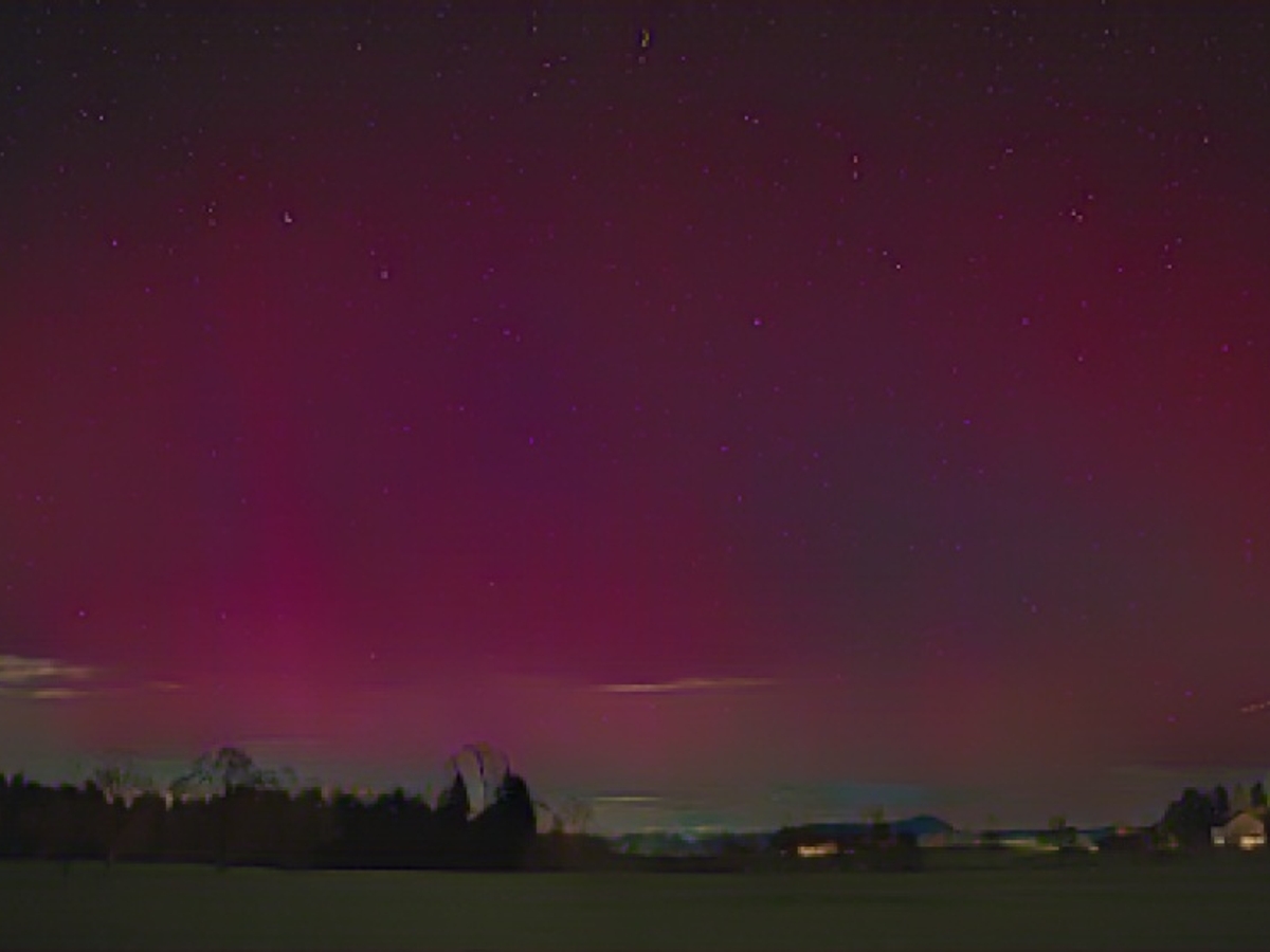 Northern lights illuminate the foothills of the Alps