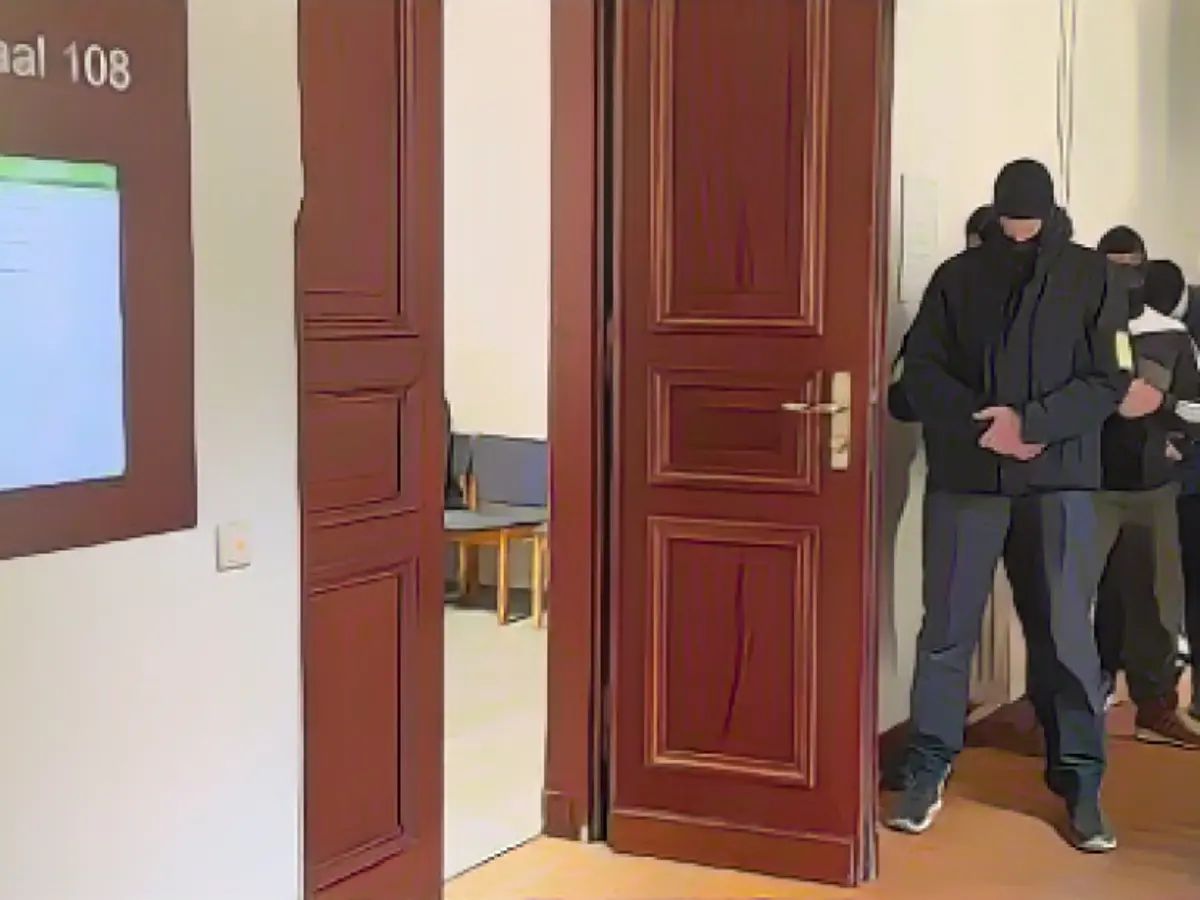 Elite police officers wait outside the courtroom for access