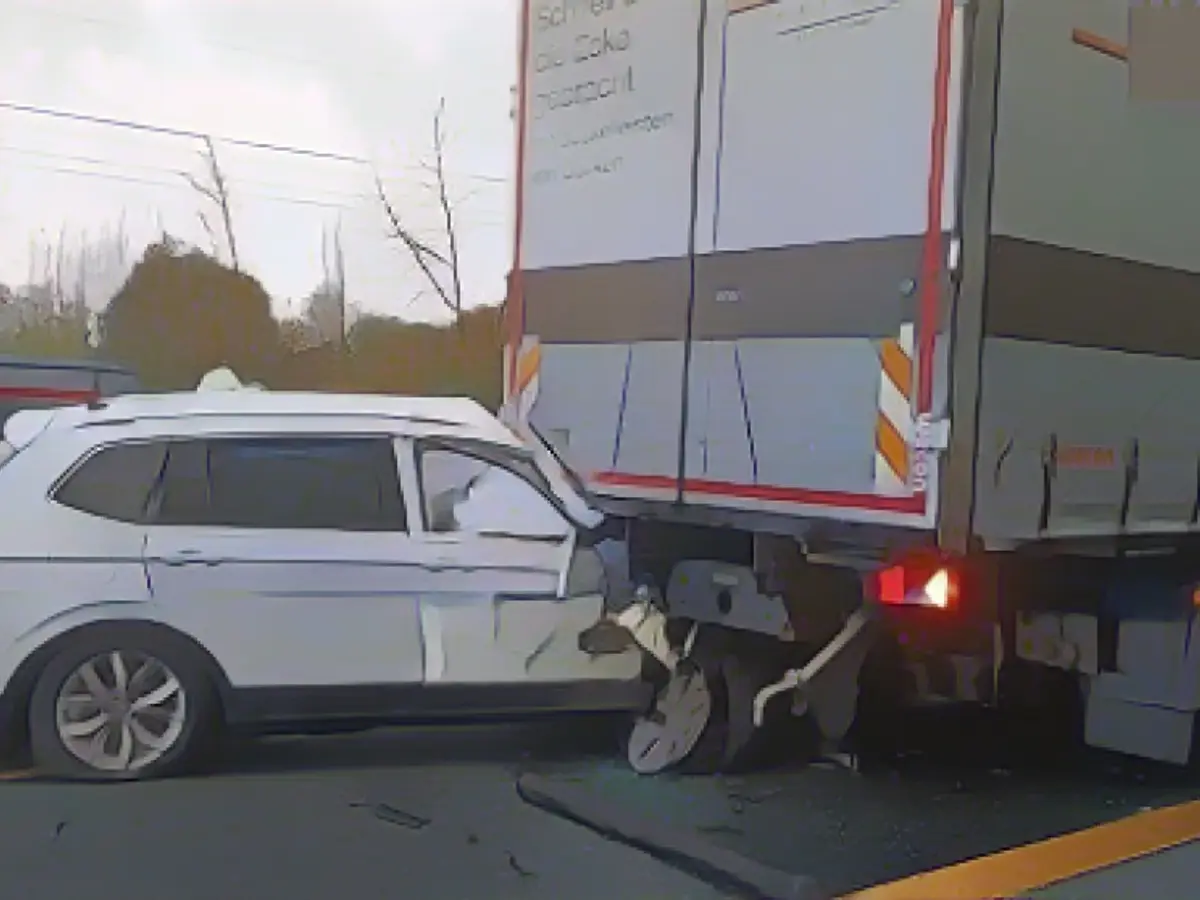 Car slides under truck - woman seriously injured